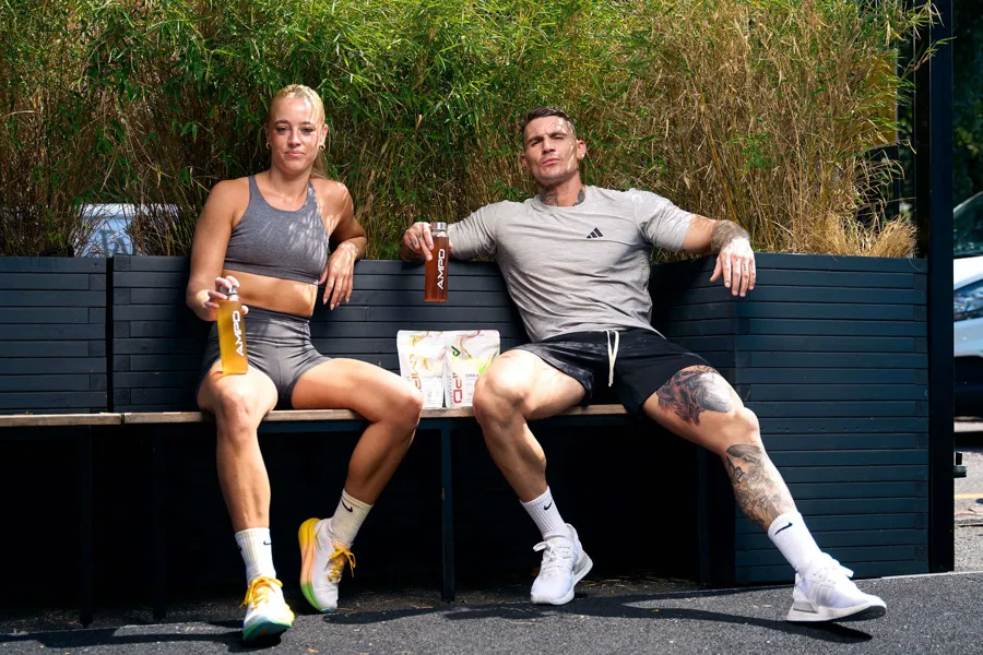 Ross and an athlete relaxing outside with AMPD bottles and both Creatine+ pouches